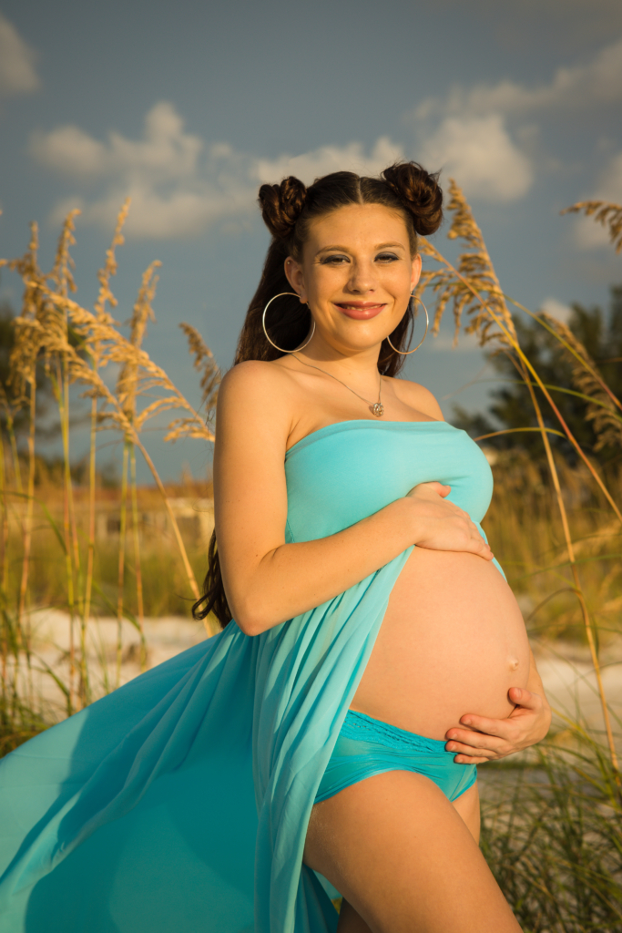 young woman's maternity photo at Anna Marie Island at sunset