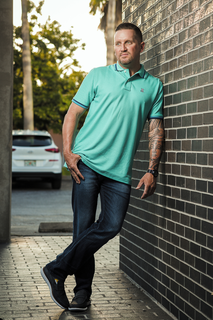 man leans against a brick wall