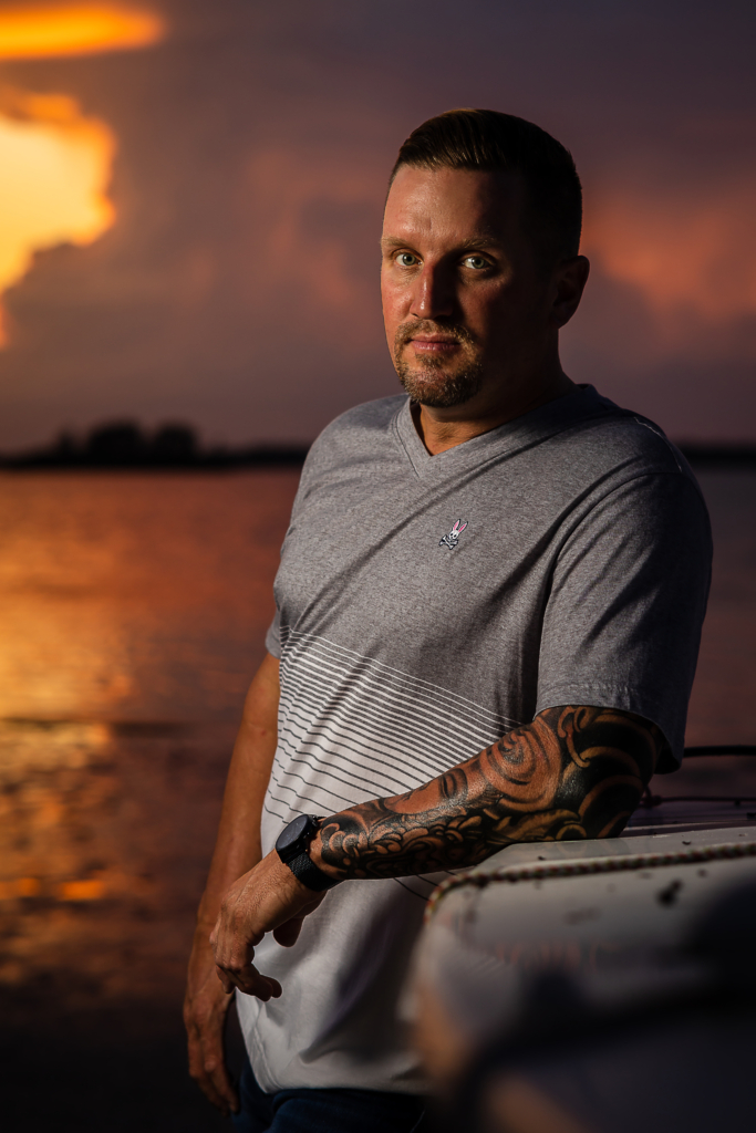 man stands in front of a sunset